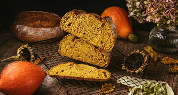 Die orangene Krume eines aufgeschnittenen Kürbis-Sauerteigbrotes mit krachender Kruste