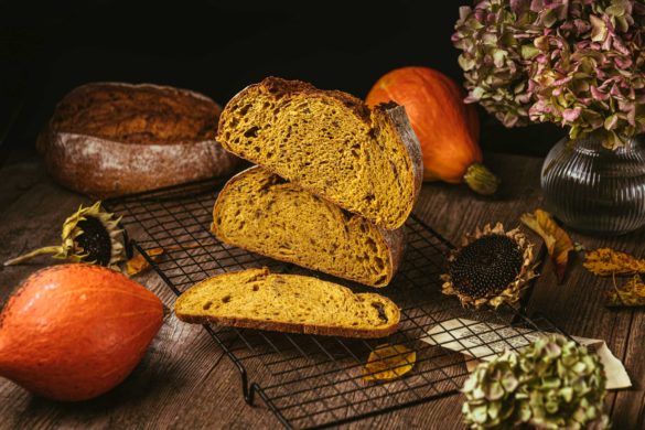 Die orangene Krume eines aufgeschnittenen Kürbis-Sauerteigbrotes mit krachender Kruste