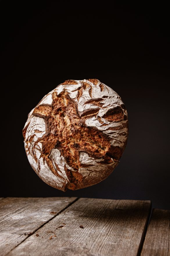 Ein dunkles Bauernbrot auf einem rustikalen Holzhintergrund bereit zum Genießen